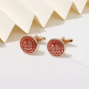 Macro view of gold cufflinks featuring red enamel and Chinese double happiness symbol