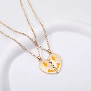 Detailed close-up of matching heart BFF necklaces with yellow enamel smiley faces