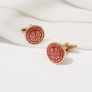Detail view of round gold cufflinks with red enamel and Chinese Double Happiness symbol