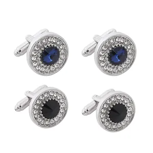 Detailed view of silver cufflinks with black and blue gems and sparkling crystal halos
