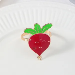 Dettaglio portatovagliolo a carota con anello dorato su piatto di ceramica bianca