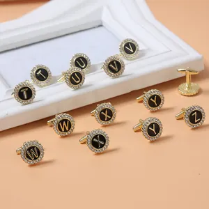 Detailed view of gold alphabet cufflinks featuring black enamel and sparkling crystals