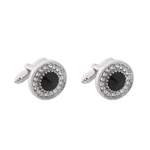 Polished silver cufflinks with black round stone and crystal halo on white background