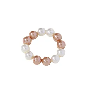 Elegantes servilleteros de perlas blancas y oro champán para decoración de mesa de lujo