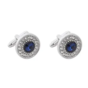 Detailed view of silver cufflinks with a dark blue crystal and sparkling zircon halo