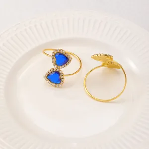 Macro shot of a gold napkin ring with a heart-shaped blue gem and sparkling crystals