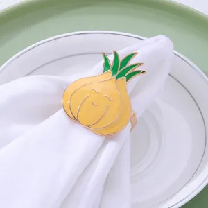Dettaglio portatovagliolo a forma di cipolla in smalto giallo con viso sorridente e piatto