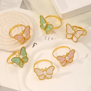 Vista detallada de servilleteros de mariposa en rosa, verde y blanco con perlas