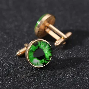 Dettaglio macro di gemelli dorati con cupola in vetro occhio del diavolo verde su nero