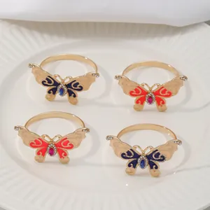 Detalle de servilleteros de mariposa con esmalte azul y rojo y cristales brillantes