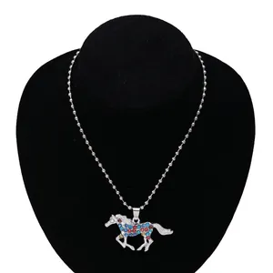 Detail of silver unicorn pendant with colorful rhinestones on a black velvet display
