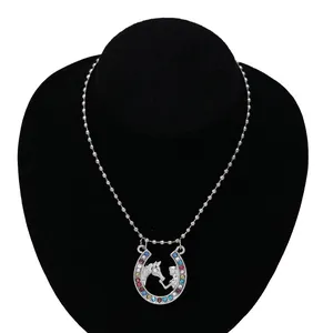 Detail of silver horseshoe necklace with colorful rhinestones on black stand