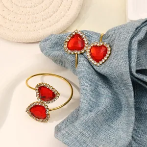 Close-up of red heart jewelry napkin ring with sparkling crystals on gold plating