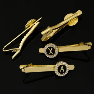 Detailed view of gold-plated round brooches with X and A crystal-encrusted letters