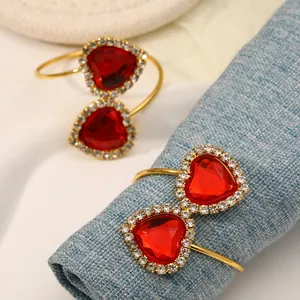 Detail of golden heart-shaped napkin rings with red crystal and micro-pave diamonds