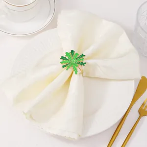 Dettaglio del portatovagliolo a fiocco di neve in smalto verde con base dorata elegante