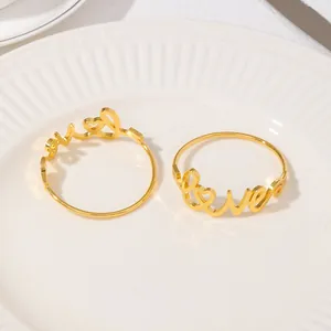 Détail d'un rond de serviette doré LOVE avec motif cœur sur une assiette blanche