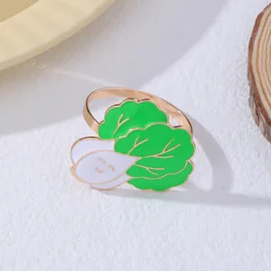Dettaglio ravvicinato di un anello in smalto a forma di cavolo con un simpatico sorriso