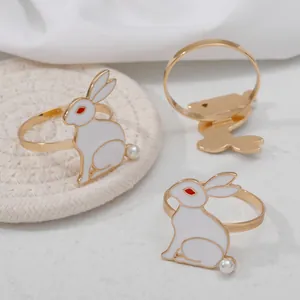 Detalle de servilleteros de conejo dorado con esmalte blanco y detalle de perla