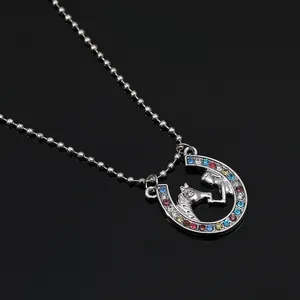 Detailed view of horsehoe lucky charm pendant with multi-color rhinestones and bead chain