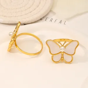 Detalle de servilleteros de mariposa dorados con incrustaciones de nácar y perlas