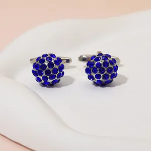 Detailed view of spherical cufflinks with deep blue crystals on a textured silver base