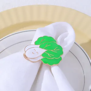 Dettaglio portatovagliolo in smalto bok choy su piatto di porcellana bianca e oro