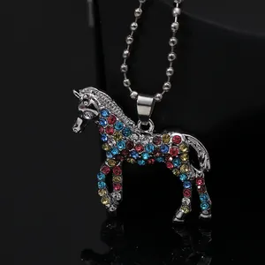 Close-up of unicorn pendant necklace with colorful rhinestones on a dark background