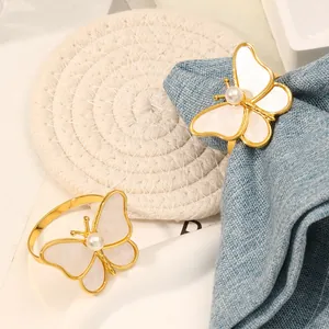 Detalle de servilleteros de mariposa dorados con nácar y acabado elegante refinado