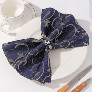 Détail d'un rond de serviette Love argenté avec serviette en jacquard bleu marine