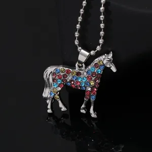 Macro shot of silver unicorn pendant with vibrant colorful rhinestones and bead chain