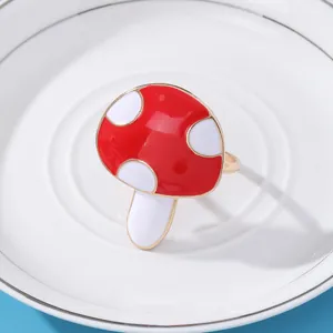 Dettaglio del portatovagliolo a forma di fungo con smalto rosso su sfondo di piatto