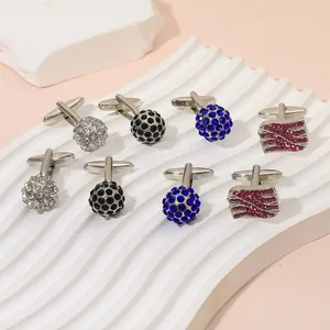 Detailed display of assorted crystal cufflinks with silver metal bases on a textured stand