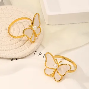 Detalle de servilleteros de mariposa dorada con incrustaciones de perlas y nácar