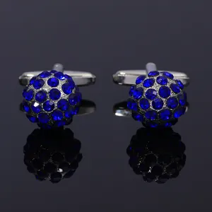 Macro shot of silver alloy cufflinks featuring deep blue faceted crystals on a black base