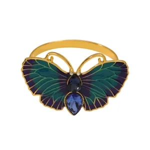 Servilletero de mariposa dorada con esmalte azul-verde y pedrería en forma de gota de agua