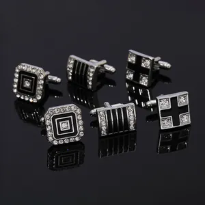 Three pairs of elegant silver and black cufflink sets with inset crystals on black base