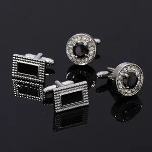 Detail view of business cufflinks with black panels and crystal inlay on reflective surface