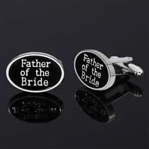 Detalle de gemelos ovalados plateados con texto Father of the Bride sobre esmalte negro