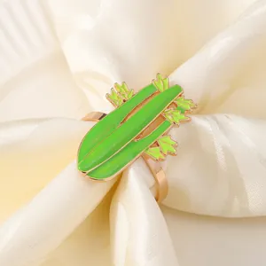 Dettaglio portatovagliolo a forma di verdura verde brillante con base dorata