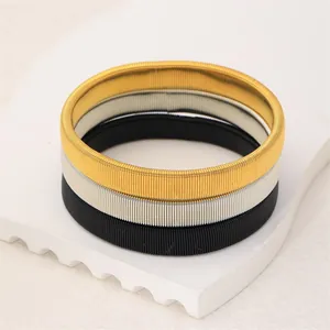 Detailliertes Set aus drei Metall-Federarmbändern in Gold, Silber und Schwarz