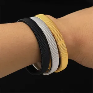 Nahaufnahme flexibler Ärmelhalter aus Metall in Schwarz, Silber und Goldoptik
