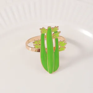 Dettaglio portatovagliolo a forma di sedano con finitura oro e smalto verde
