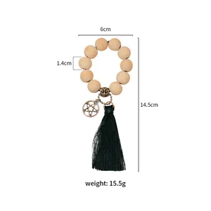 Detail showing wooden bead napkin ring with green tassel and decorative bronze charm