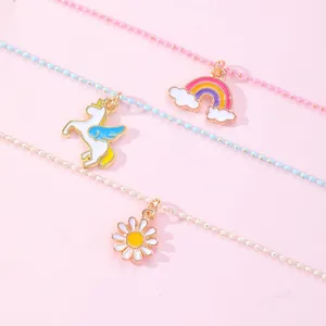 Detailed close-up of rainbow, unicorn, and daisy pendant necklaces for best friends