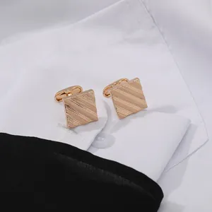 Men's square rose gold cufflinks with elegant striped patterns on white shirt cuffs