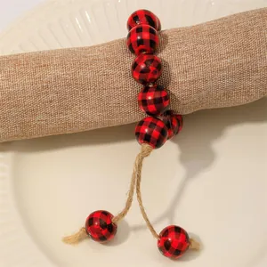 Dettaglio dell'anello per tovaglioli con perline di legno a quadri e nappe in juta