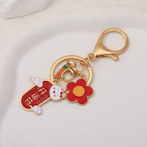 Close-up of golden rabbit keychain with red fortune charm and white bunny detail