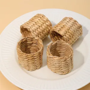 Detalle macro de 4 servilleteros trenzados de jacinto de agua en un plato de cerámica