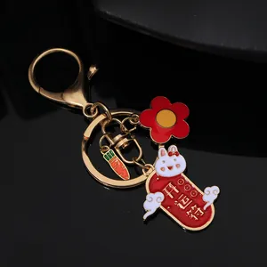 Detail of golden Chinese zodiac rabbit keychain with red lucky charm and carrot pendant
